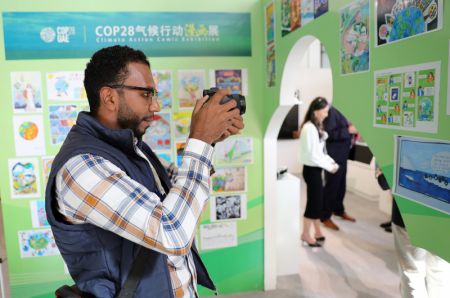 (miniature) Un visiteur du pavillon chinois lors de la 28e session de la Conférence des parties à la Convention-cadre des Nations Unies sur les changements climatiques (COP28)