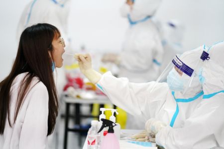 (miniature) Une habitante reçoit un test d'acide nucléique dans un point de tests de l'arrondissement de Nangang à Harbin