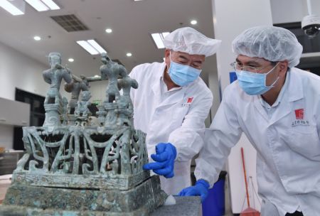(miniature) Guo Hanzhong (à gauche) discute avec un collègue du plan de restauration d'un autel en bronze au musée de Sanxingdui de la ville de Guanghan