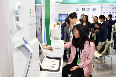 (miniature) Une visiteuse découvre un moniteur de santé intelligent au Centre de conférence international de Changsha lors de la deuxième conférence du Forum sur le développement économique et la sécurité du monde dans le cadre du Forum de Boao pour l'Asie (FBA) à Changsha