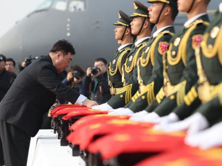 (miniature) L'ambassadeur de Chine en République de Corée Xing Haiming recouvre de drapeaux nationaux chinois les cercueils contenant les dépouilles de martyrs des Volontaires du peuple chinois (VPC)