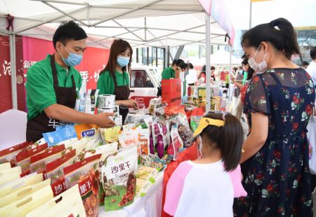 (miniature) Des employés présentent des produits agricoles aux consommateurs lors d'une activité à Beijing