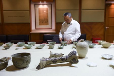 (miniature) Un chercheur examine des céramiques découvertes sur le site archéologique de l'ancien port de Shuomen à Wenzhou