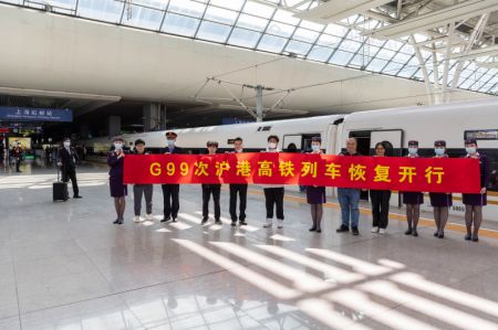 (miniature) Des passagers posent pour une photo de groupe avec des membres du personnel du train numéro G99 à la gare Hongqiao de Shanghai