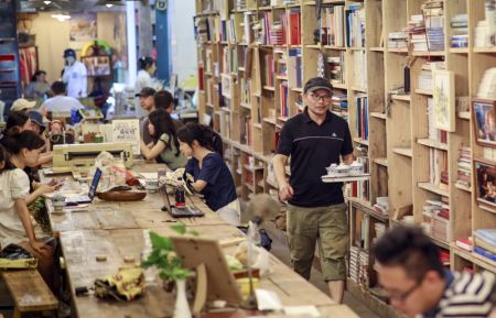 (miniature) Le patron d'une librairie offre du thé à des lecteurs dans une librairie rénovée sur la base d'un ancien abri anti-aérien dans l'arrondissement de Jiulongpo