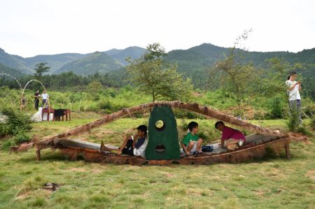 (miniature) Des enfants s'amusent à l'intérieur d'une installation artistique dans le district de Ningyuan de la province chinoise du Hunan (centre)