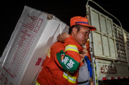 (miniature) Un secouriste transporte du matériel de secours à Yangbi