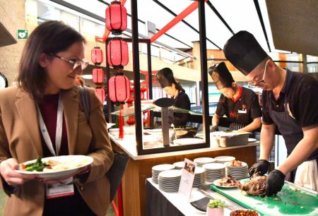 (miniature) Une participante à la 14e réunion de la Conférence des Parties contractantes (COP14) à la Convention de Ramsar sur les zones humides goûte un canard laqué lors d'une dégustation de cuisine chinoise