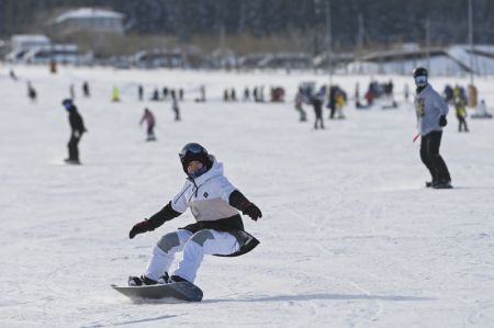(miniature) Des gens font du surf des neiges dans une station de ski à Urumqi
