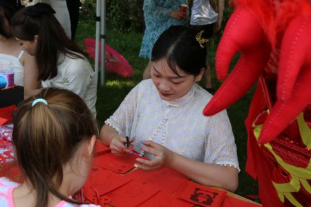 (miniature) Une artiste démontre l'art du découpage du papier chinois lors d'un festival culturel des bateaux-dragons à Sofia