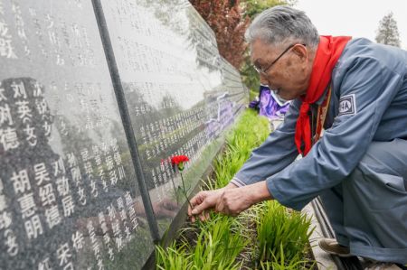(miniature) Le vétéran Feng Guoliang dépose une fleur devant un mur commémoratif à Shanghai