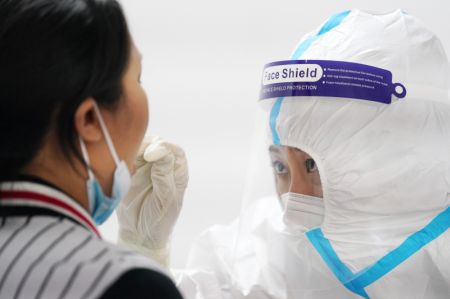 (miniature) Une habitante reçoit un test d'acide nucléique dans un point de tests de l'arrondissement de Nangang à Harbin