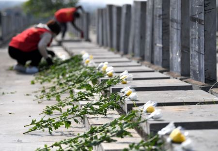 (miniature) Des bénévoles rendent hommage aux défunts au nom des personnes en deuil dans un cimetière du district de Feixi