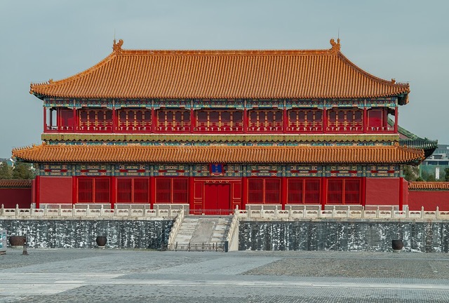 Le belvédère de la Bienveillance incarnée vu de face : un bâtiment rouge à deux niveaux sous deux toits de tuiles jaunes, une galerie à balustrade rouge à l’étage, posé sur un soubassement de pierre grise.