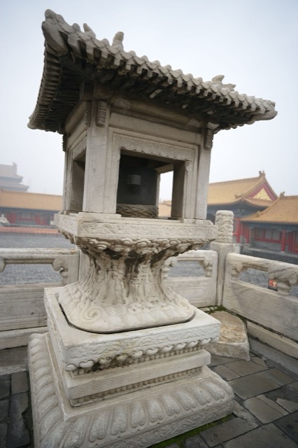 Un petit pavillon de pierre sculpté, à toit et balustrade, posé sur la terrasse du palais de la Pureté céleste, dans la brume.