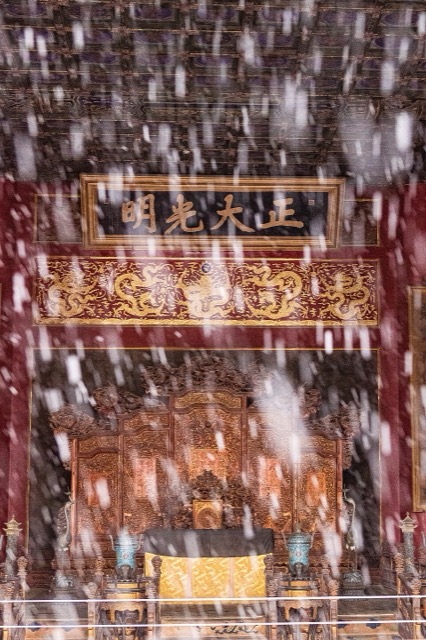Le trône et la tablette calligraphiée du palais de la Pureté céleste aperçus à travers un rideau de flocons de neige.