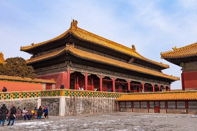 Le palais de la Tranquillité terrestre vu de biais en hiver, avec son double toit de tuiles jaunes et le mur de briques vernissées de sa terrasse.