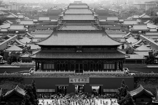 Vue plongeante en noir et blanc sur la porte de la Prouesse divine et, derrière elle, l’enfilade des toits de la Cité interdite jusqu’à l’horizon.