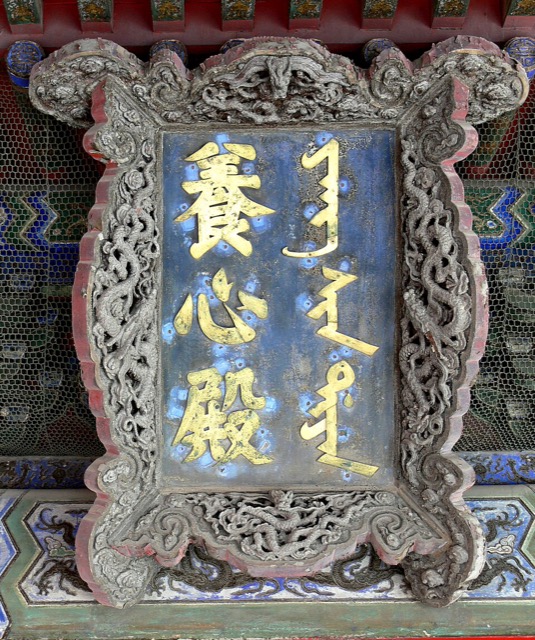 Gros plan sur la plaque de la salle de la Culture de l’esprit : caractères dorés sur fond bleu, en chinois et en mandchou, dans un cadre sculpté de dragons.