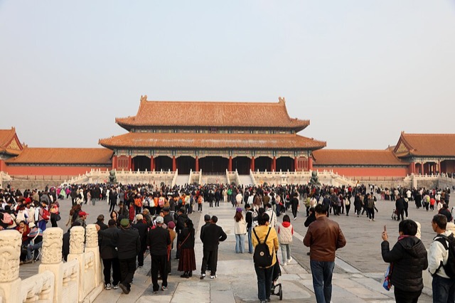 La porte de l’Harmonie suprême vue de face dans l’axe, avec ses deux toits superposés et ses trois escaliers, devant laquelle se presse une foule de visiteurs.