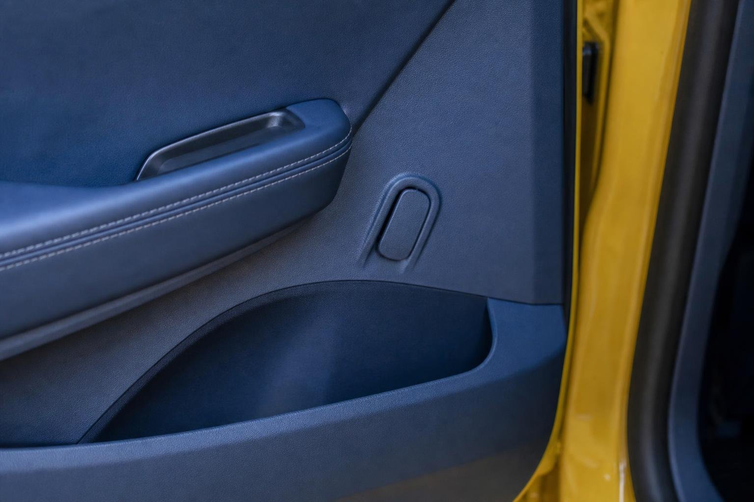 Levier de secours d'une portière peint dans la même couleur que la garniture intérieure d'une voiture électrique