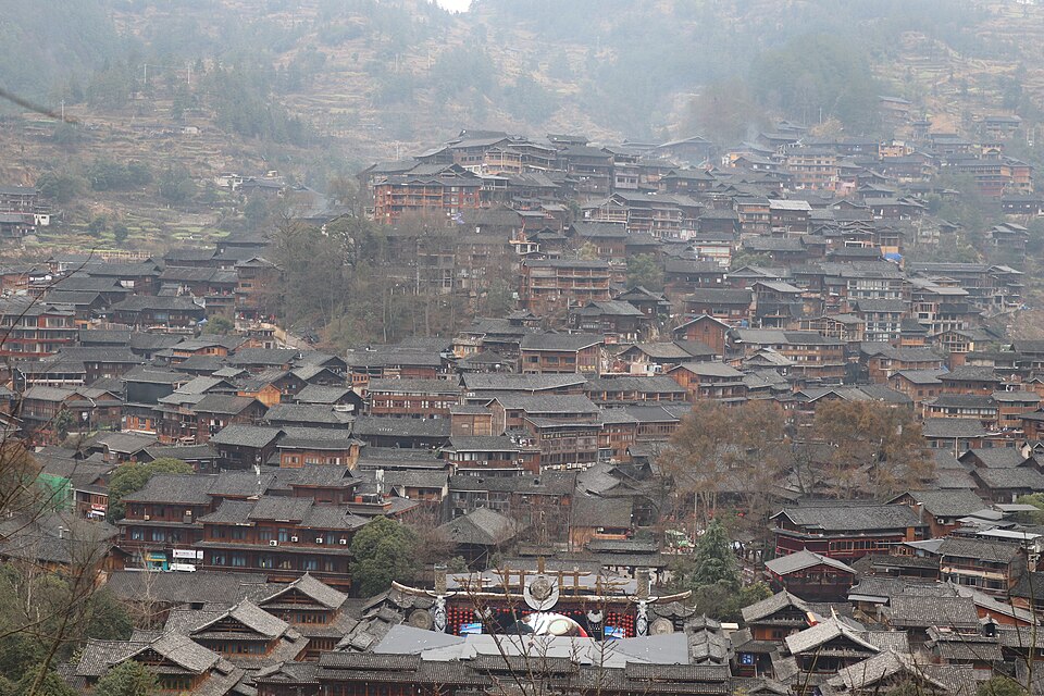 Des centaines de maisons de bois sombre s'empilent sur tout le versant, leurs toits gris se chevauchant jusqu'en haut de la colline, dans une lumière d'hiver laiteuse.