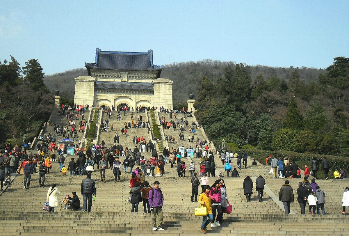 Le grand escalier du mausolée de Sun Yat-sen à Nankin, couvert de visiteurs, menant au hall funéraire au toit de tuiles bleues