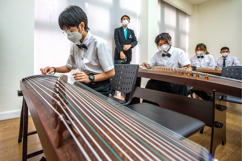 Des gens apprennent à jouer du guzheng