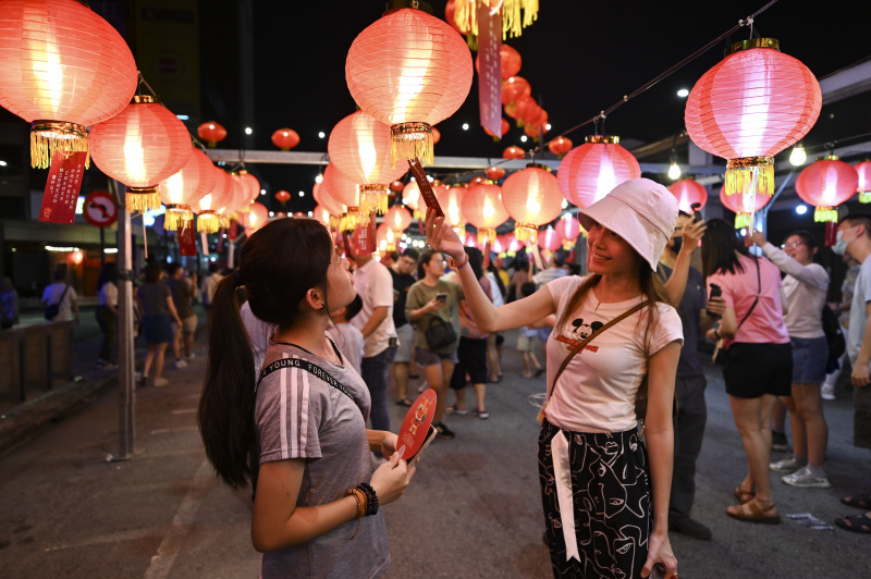 Des festivaliers jouent aux devinettes inscrites sur les lanternes lors d'une célébration du Nouvel An chinois à George Town dans l'Etat de Penang