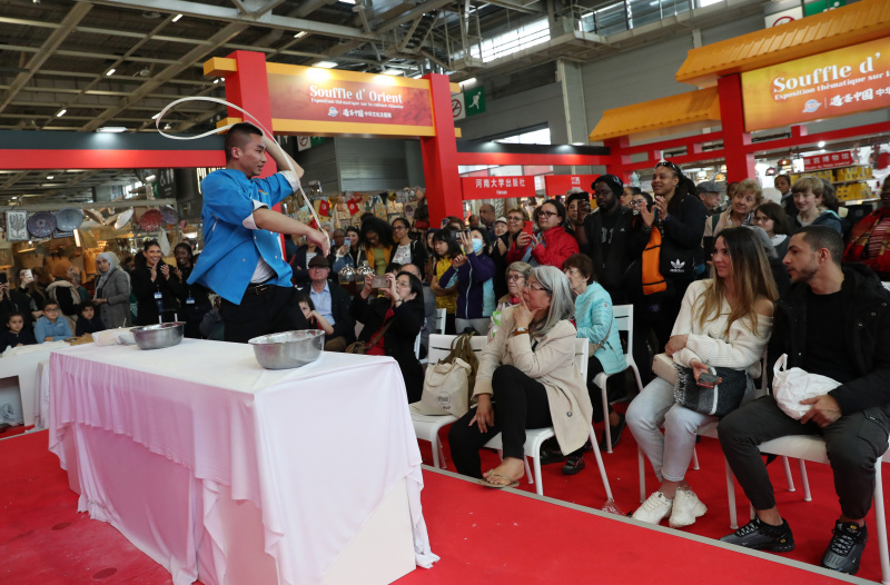 Un chef cuisinier fait une démonstration d'étirement de nouilles lors d'une exposition sur la culture chinoise au centre d'exposition de la Porte de Versailles à Paris