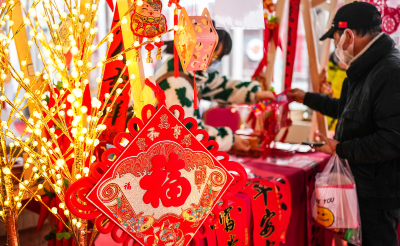 Un habitant choisit des décorations à l'approche de la fête du Printemps à la place Lanhua dans l'arrondissement de Nanming