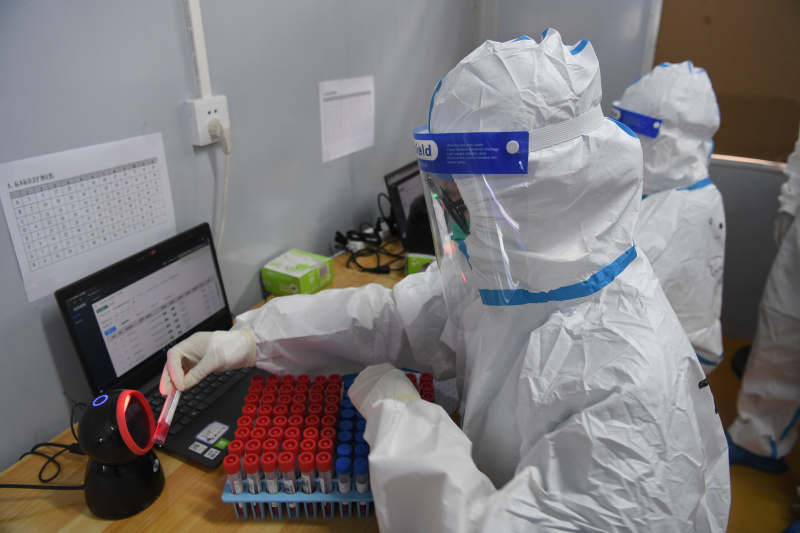 Des professionnels de santé scannent les codes des échantillons d'acide nucléique dans un laboratoire de dépistage à Sanya