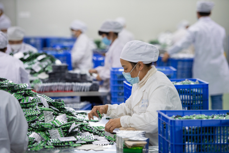 Des membres du personnel emballent des médicaments dans une entreprise pharmaceutique de la province chinoise du Hunan (centre)