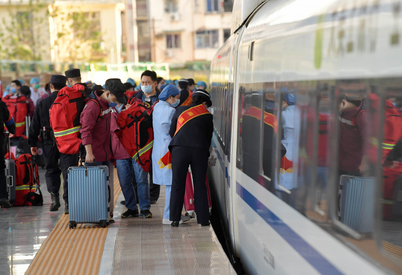 Des professionnels de santé montent dans un train à destination de Shanghai