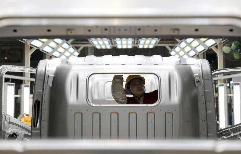 Un employé travaille sur une ligne d'assemblage de camions dans une base de production de l'Anhui Jianghuai Automobile Group Corp
