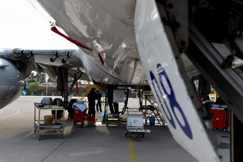 Des techniciens démantèlent un avion à l'aéroport international Xinqiao de Hefei