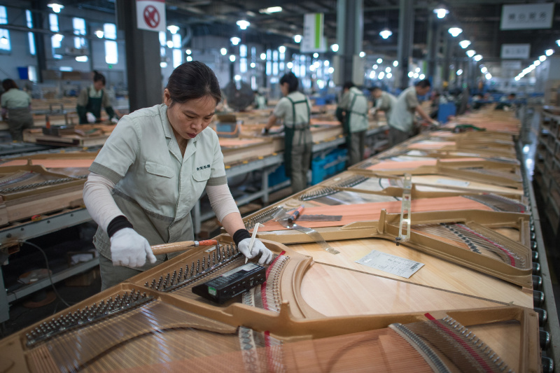 Une ouvrière dans une fabrique de pianos de Parsons Music Corporation