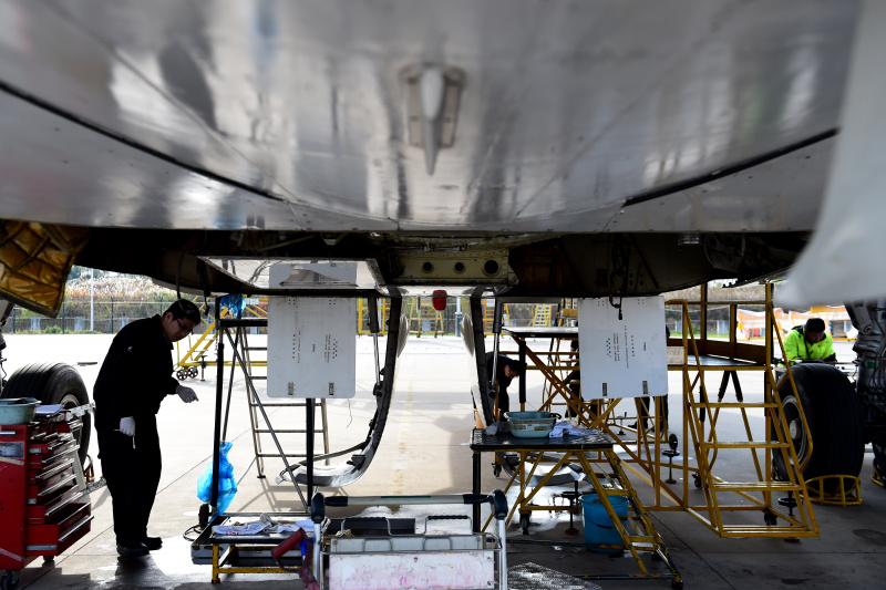Des techniciens démantèlent un avion à l'aéroport international Xinqiao de Hefei