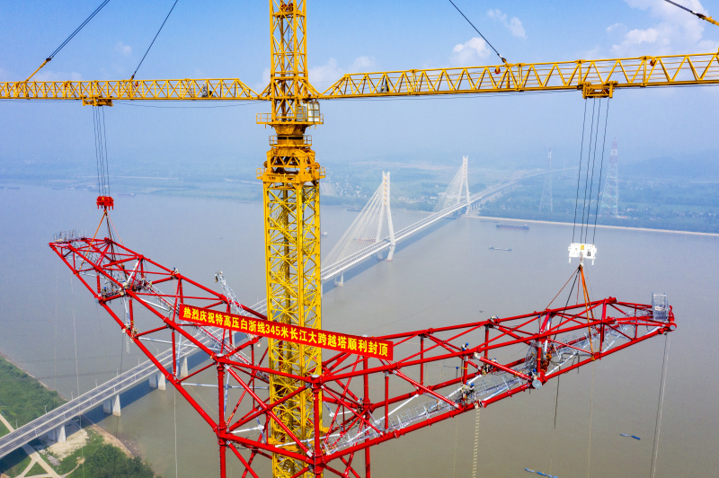 Photo aérienne montrant le site de construction d'un pylône de transmission à longue portée du projet de transmission d'électricité à ultra-haute tension (UHV) Baihetan-Zhejiang au bord du fleuve Yangtsé