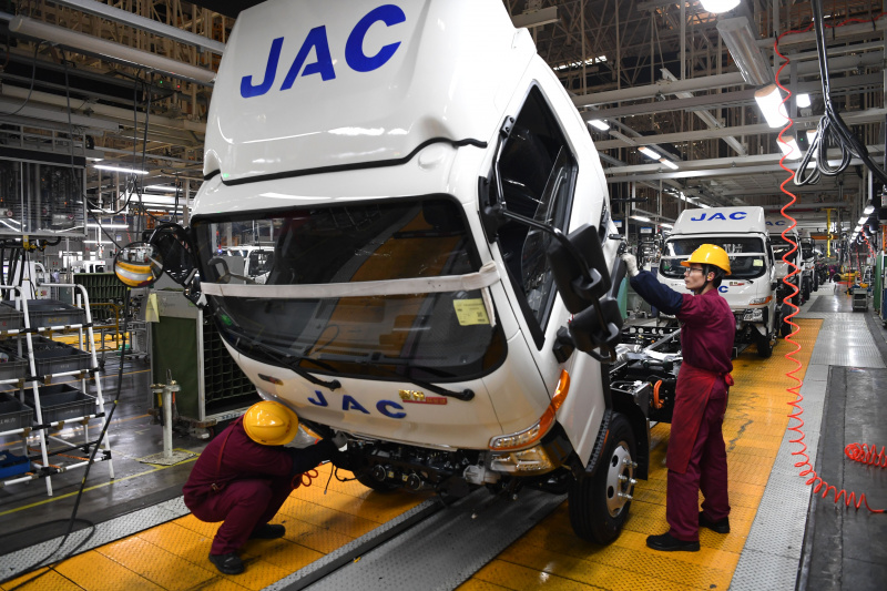 Des employés travaillent sur une ligne d'assemblage de camions dans une base de production de l'Anhui Jianghuai Automobile Group Corp