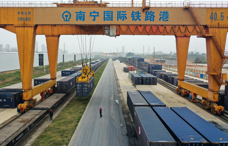 Une grue à portique charge des conteneurs sur un train de fret à destination du Kazakhstan dans le port ferroviaire international de Nanning
