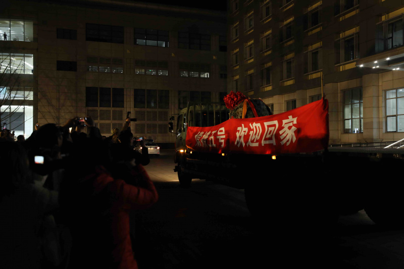 Les gens célèbrent l'arrivée de la capsule de retour de la sonde chinoise Chang'e-5 à l'Académie chinoise de technologie spatiale (ACTS) à Beijing