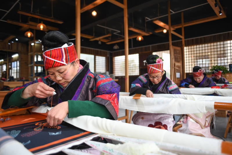 Des habitantes locales réalisent des oeuvres de broderie dans un atelier de Shibing