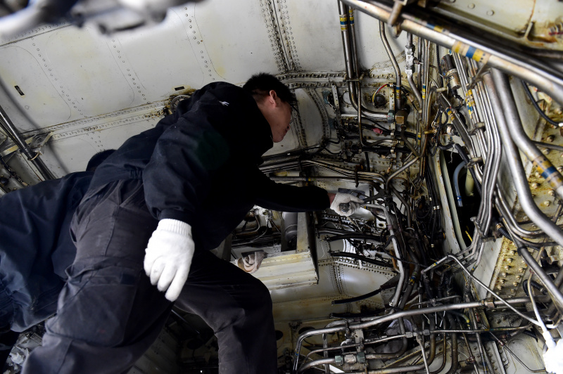 Un technicien démantèle un avion à l'aéroport international Xinqiao de Hefei