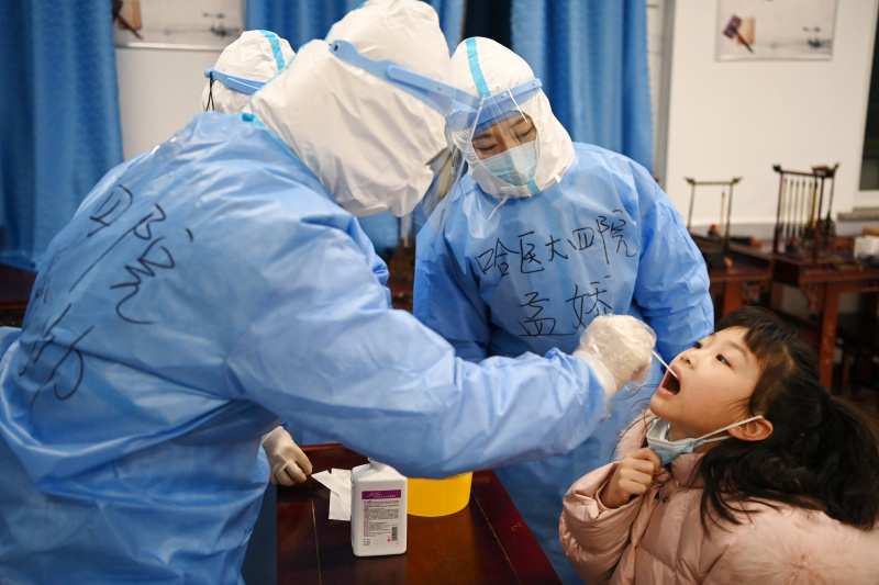 Un travailleur médical prélève un échantillon d'acide nucléique sur un site de dépistage dans un collège de Harbin