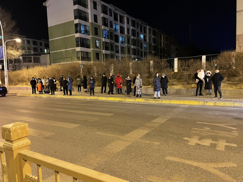 Des gens à l'extérieur de bâtiments pour échapper au séisme dans le district de Menyuan