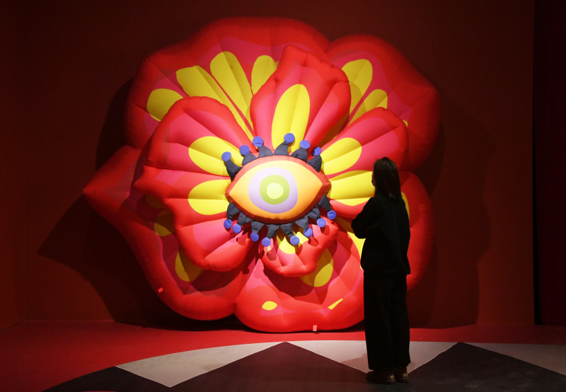 Une visiteuse contemple une installation à Blooming Echoes
