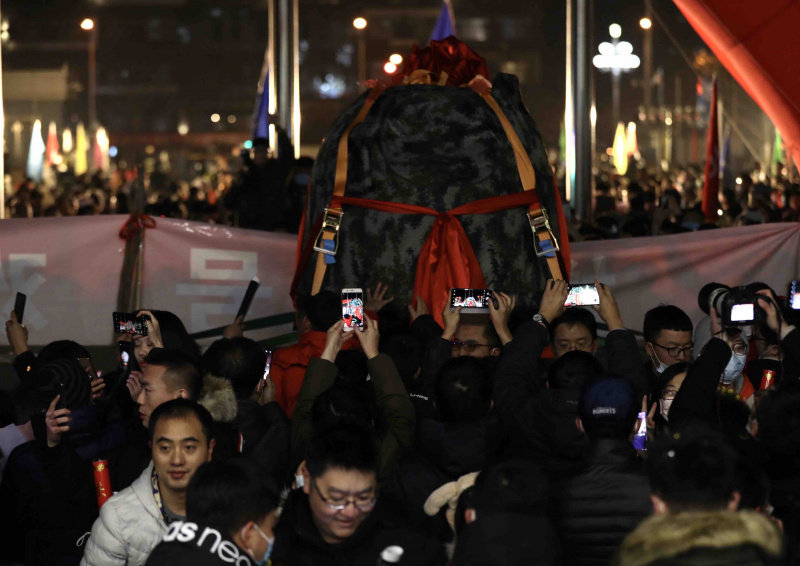 Les gens célèbrent l'arrivée de la capsule de retour de la sonde chinoise Chang'e-5 à l'Académie chinoise de technologie spatiale (ACTS) à Beijing