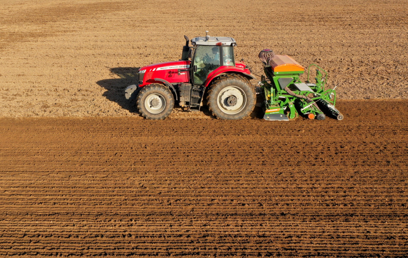 Photo aérienne d'une machine agricole semant des graines de blé d'hiver dans des champs à Yanli