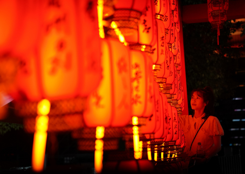 Une visiteuse admire les installations lumineuses de la fête de la mi-automne au site touristique du pavillon Tengwang